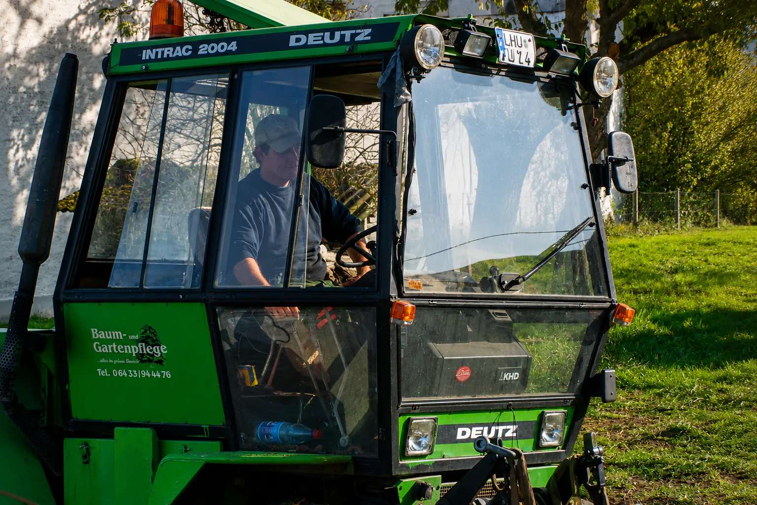 Rasenmahd und Grünflächenpflege mit leistungsfähiger Mähtechnik. Der Traktor Deutz INTRAC 2004 ist im Einsatz.