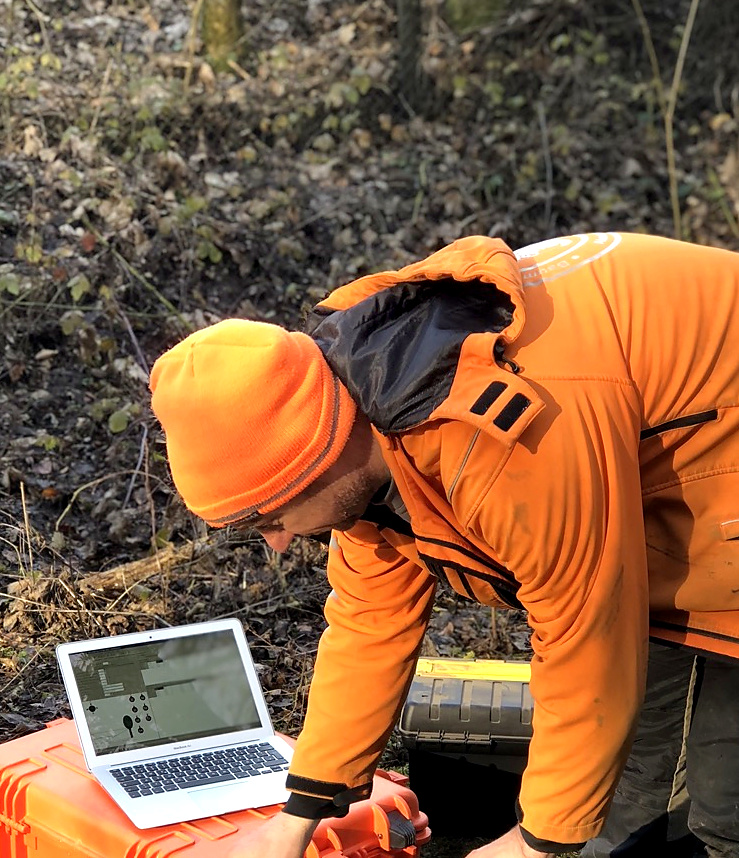 Baumsachverständiger Alexander Kraus bei einer Baumuntersuchung mit Messgerät und Laptop.