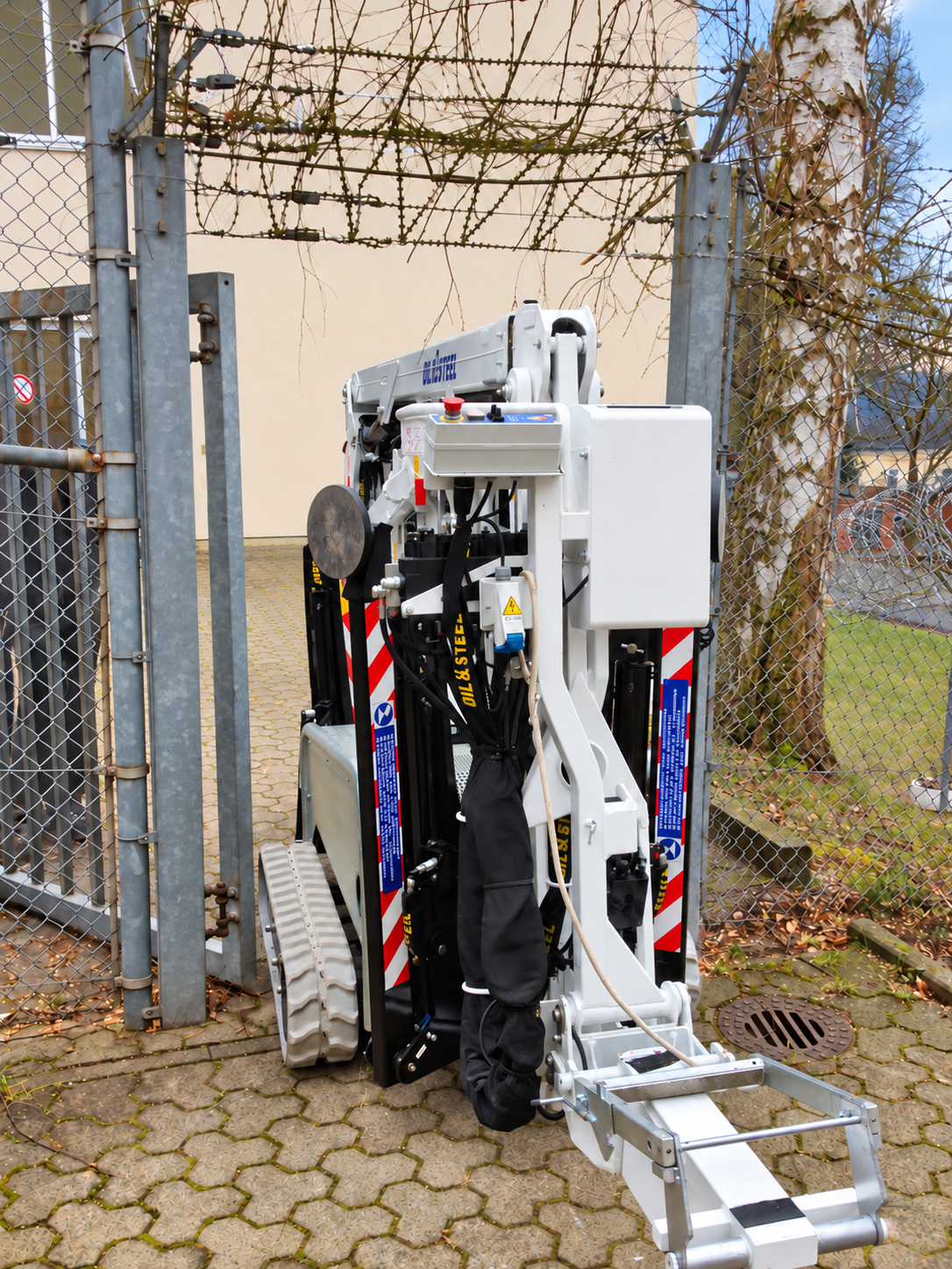 Kompakter 15-Meter-Kettensteiger der Baum- und Gartenpflege Kraus bei der Durchfahrt durch ein schmales Tor.